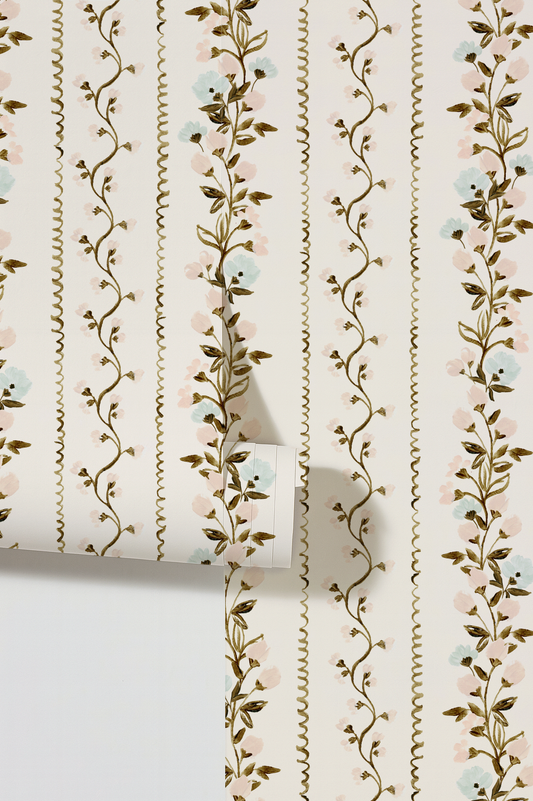 Roll of wallpaper with floral vine design on a white background