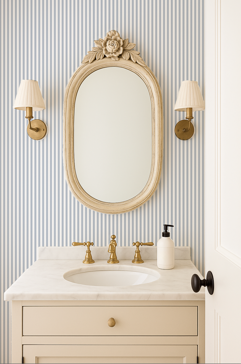 Bathroom with blue grey striped wallpaper, vintage mirror, and brass fixtures.