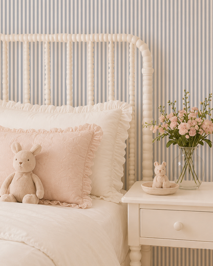Blue grey striped wallpaper in cozy bedroom with white bed and pink decor.