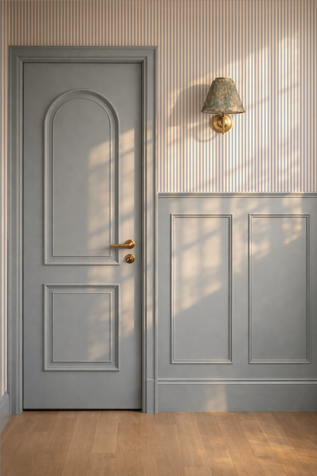 Elegant blue-grey striped wallpaper in a modern room with paneled door and wall lamp.
