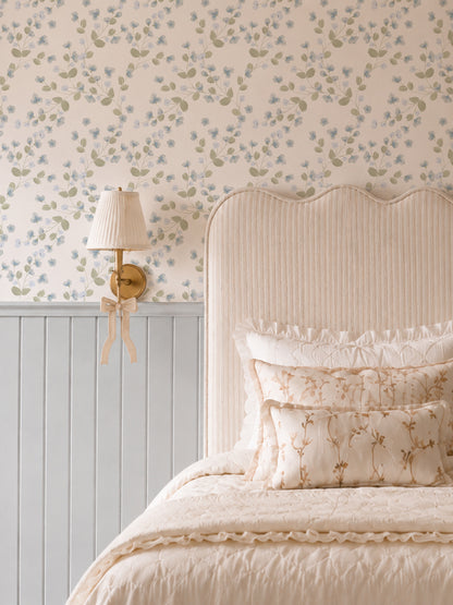 Bedroom with Bluebell ivy wallpaper featuring blue florals and green leaves, elegant bed, and lamp.