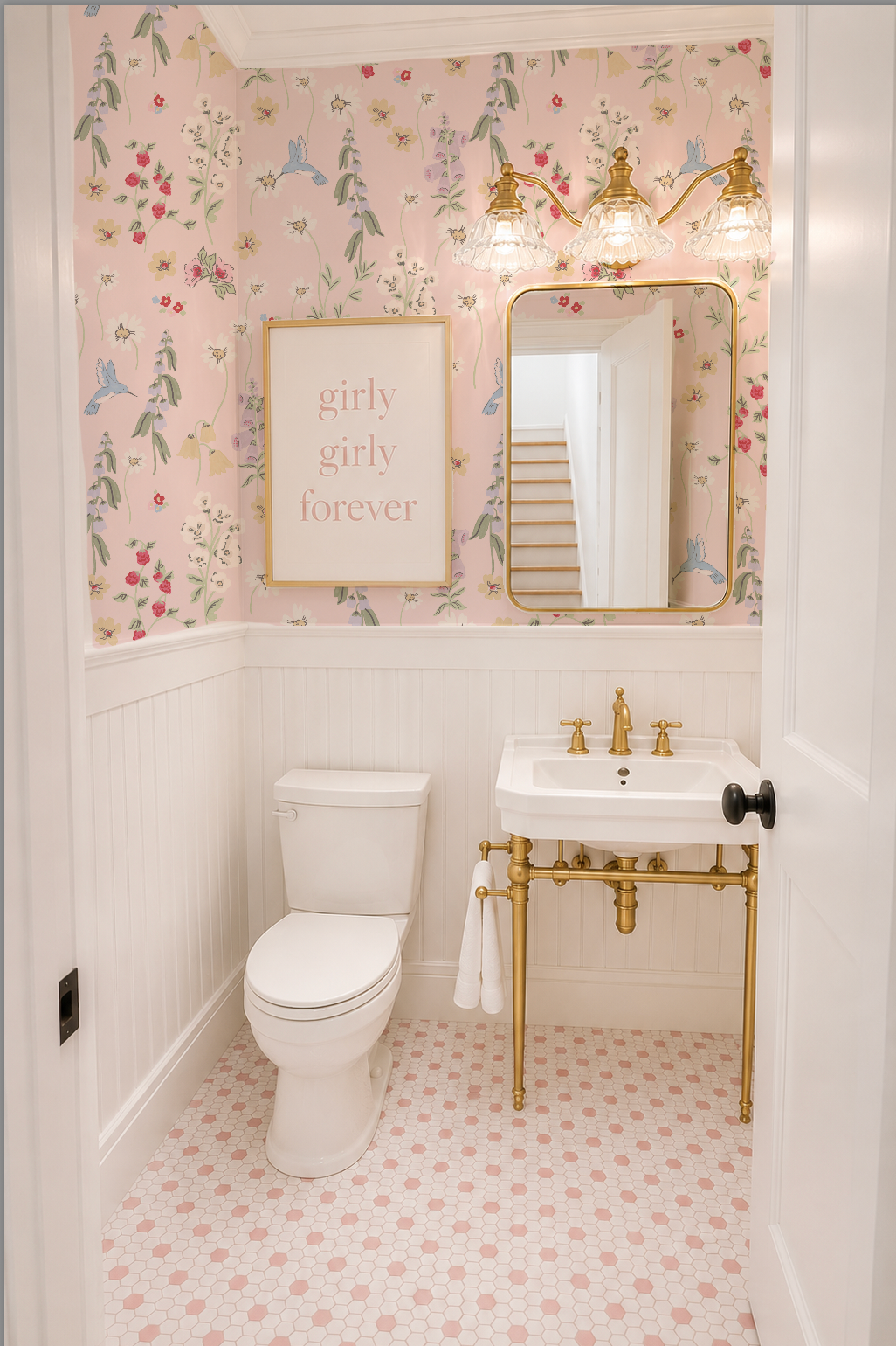Bathroom with blush floral wallpaper featuring hummingbirds and flowers, white fixtures, and gold accents.