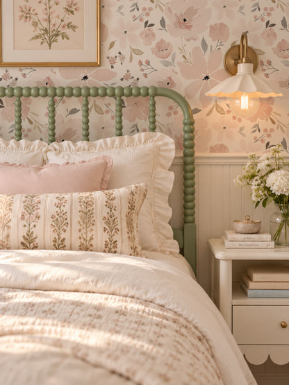 Blush floral wallpaper in cozy bedroom with green bed and soft lighting.