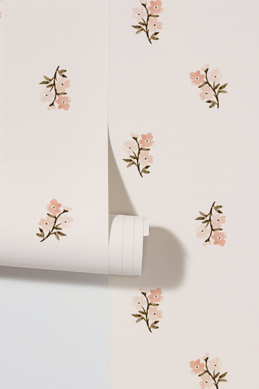 Blush floral wallpaper with small flowers on a pale background.