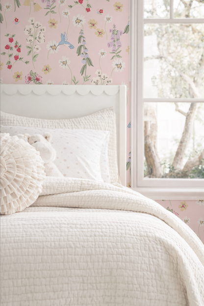 Floral hummingbird wallpaper in pink bedroom with white bedding and window view.