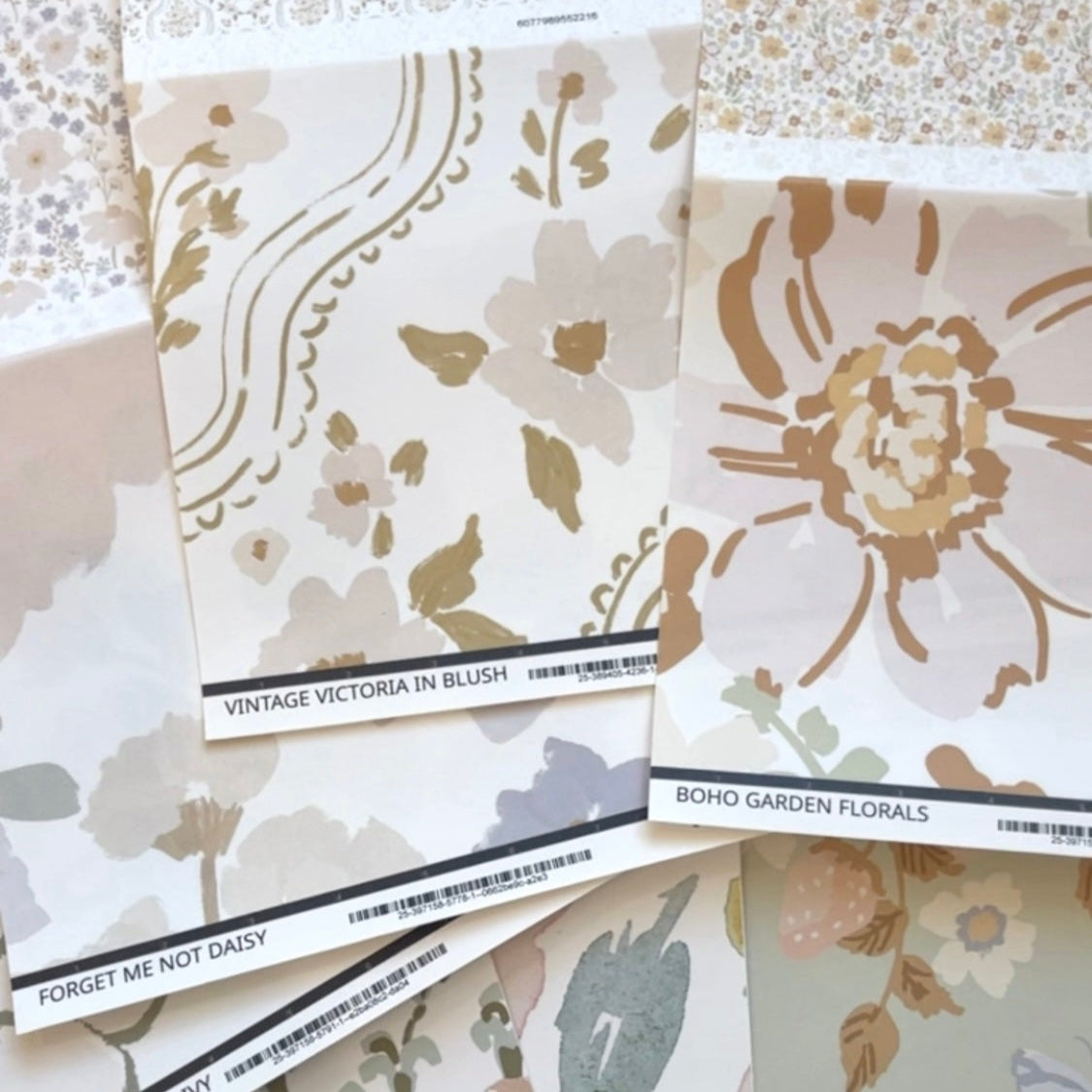 Collection of floral design peel and stick wallpaper swatches on a textured surface